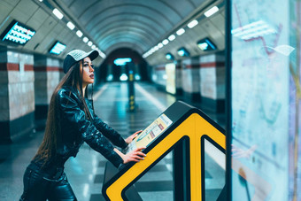 时尚风格模型女摆姿势地铁站平台华丽的浅黑肤色的女人女人地铁地图平台空站特写镜头