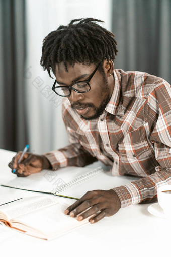 非洲美国学生读书使笔记字帖家庭作业肖像年轻的男人。眼镜研究首页图书馆教育概念