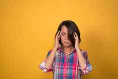 头疼女人持有头交易偏头痛站黄色的墙背景复制空间