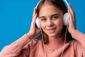 女学生耳机听音乐蓝色的背景