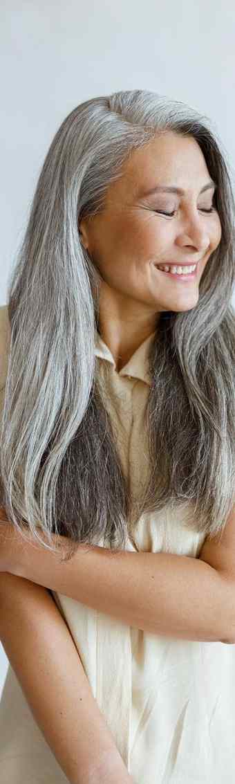 不好意思中间岁的亚洲夫人长银头发提出了光灰色背景
