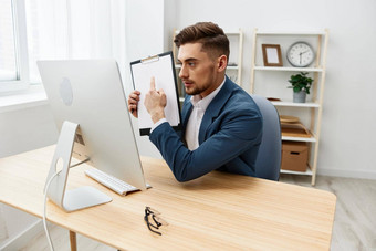 英俊的商人电脑桌面工作自信纸文件夹灰色的背景