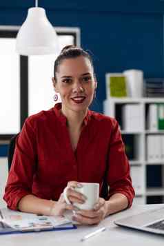 肖像成功的企业家红色的衬衫持有杯咖啡茶