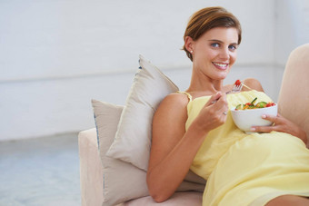 采取婴儿<strong>健康关注</strong>饮食肖像年轻的怀孕了女人享受<strong>健康</strong>的沙拉放松沙发上