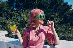 快乐的女人粉红色的头发夏天鸡尾酒让人耳目一新喝夏天一天