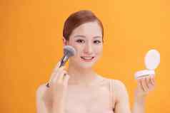 有吸引力的化妆女人脸红的人刷化妆品产品