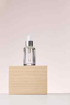 玻璃透明的白色瓶吸管站木讲台上容器化妆品酸油米色背景