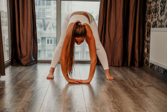 中间岁的运动有吸引力的女人练习瑜伽作品首页瑜伽工作室运动服装白色裤子全身的前在室内健康的生活方式概念