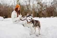 快乐的女人雪玩狗有趣的友谊冬天假期
