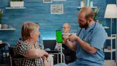 护士垂直持有智能手机绿色屏幕