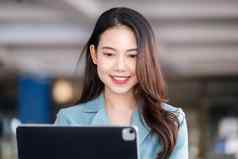 女企业家女商人显示微笑脸操作电脑平板电脑工作木表格