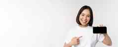 肖像微笑朝鲜文女人指出手指移动电话屏幕显示水平智能手机显示推荐网站商店在线白色背景