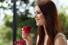 快乐的女人白色衣服饮料咖啡在户外咖啡馆不变的