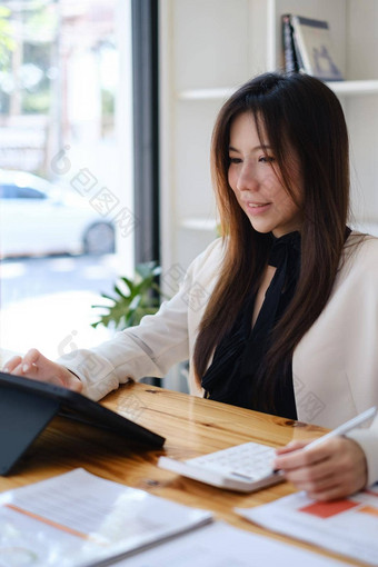 亚洲会计女人工作审计预算金融公司木桌子上办公室咨询业务税概念