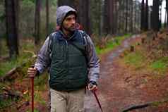 保持适合享受自然拍摄英俊的男人。徒步旅行松森林北欧走波兰人
