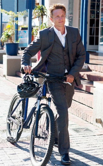 使有责任心的通勤选择拍摄有吸引力的年轻的男人。推自行车工作