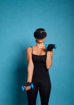 运动女人穿虚拟现实护目镜培训手臂肌肉