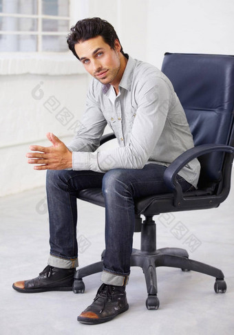 年轻的英俊的时尚的拍摄英俊的年轻的坐着椅子