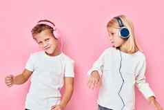 有趣的孩子们站耳机粉红色的颜色背景