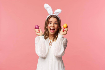 假期春天聚会，派对概念肖像兴奋迷人的年轻的女人庆祝复活节兔子耳朵白色聚会，派对衣服跳舞画鸡蛋粉红色的背景