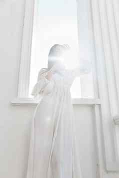 女人白色衣服射线太阳窗口摆姿势