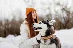 女人纯种狗户外游戏雪有趣的旅行生活方式