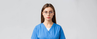 医疗保健工人医学保险科维德流感大流行概念年轻的女实习生护士医生实习医生风云眼镜相机表达式灰色背景