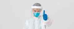 科维德冠状病毒疾病医疗保健工人概念严肃的表情自信亚洲女医生医生个人保护设备呼吸器显示竖起大拇指白色背景