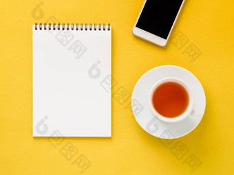 前视图现代明亮的黄色的办公室桌面空白记事本杯茶智能<strong>手机模拟</strong>空空间