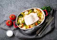 鱼鳕鱼烤烤箱蔬菜健康的饮食健康的食物灰色的石头背景复制空间前视图