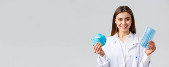 科维德防止病毒医疗保健工人概念微笑有吸引力的女医生白色实习医生风云显示变体个人保护设备显示呼吸器医疗面具