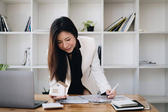 女人持有检查房子模型真正的房地产房子评估检查保险概念