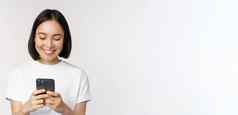 肖像微笑亚洲女人移动电话聊天发短信消息站T恤白色背景