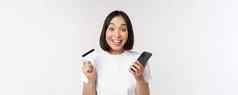 在线购物快乐亚洲女人信贷卡智能手机应用程序支付网站移动电话白色背景