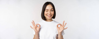 <strong>优秀</strong>的微笑亚洲女人显示标志批准手势满意推荐smth站白色背景