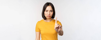 肖像亚洲女人愤怒的显示停止禁止手势禁忌标志禁止smth站黄色的T恤白色背景