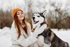 快乐的女人雪玩狗有趣的友谊生活方式