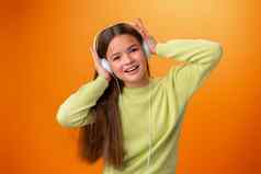 肖像现代快乐青少年学校女孩耳机橙色背景