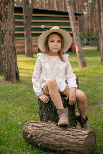 13岁以下的女孩坐着木树桩绿色草坪上夏天公园