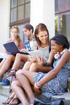 教室年轻的青少年分享笔记笔记本电脑数字平板电脑在户外