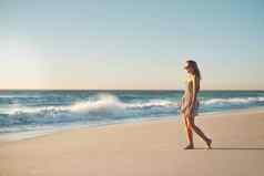 海滩拍摄年轻的女人采取漫步海滩