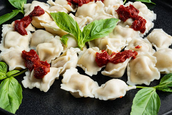 意式馄饨意大利面蘑菇奶油酱汁奶酪意大利食物风格罗勒帕尔玛西红柿黑色的板黑色的背景
