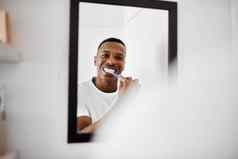 健康的牙齿拍摄年轻的男人。刷牙牙齿浴室镜子