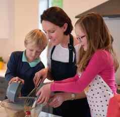 妈妈爱帮助手厨房拍摄可爱的孩子们帮助妈妈。烤厨房首页