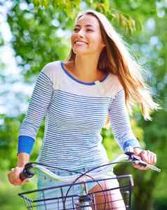 令人愉快的周期拍摄年轻的女人骑自行车公园