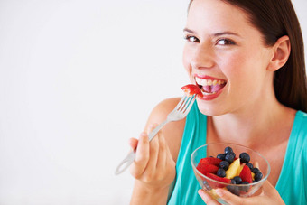 吃水果一天肖像有吸引力的年轻的女人享受水果沙拉