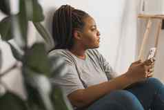 肖像非洲美国女学生穿着随便持有移动电话打字消息沟通朋友社会网络高互联网连接