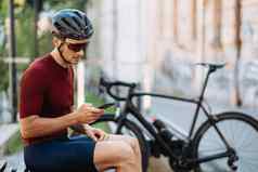 男人。体育运动衣服智能手机骑自行车