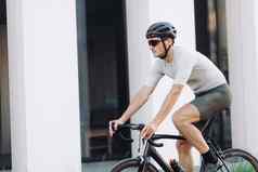 男人。安全头盔骑黑色的自行车城市街道