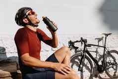 快乐骑自行车的人喝水在户外活动